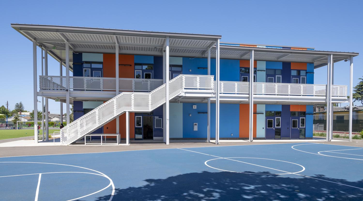 Exterior view of the two-story classroom building and exterior stair system at Achieve Academy in Oakland, California