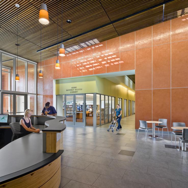 Information desk in main lobby with library in the background