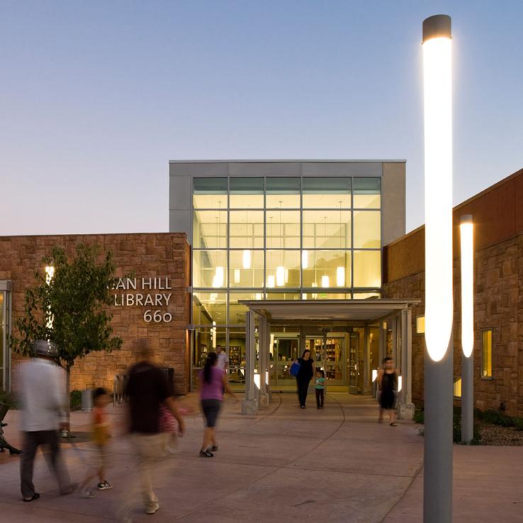 Exterior view at dusk with glowing entrance and public plaza