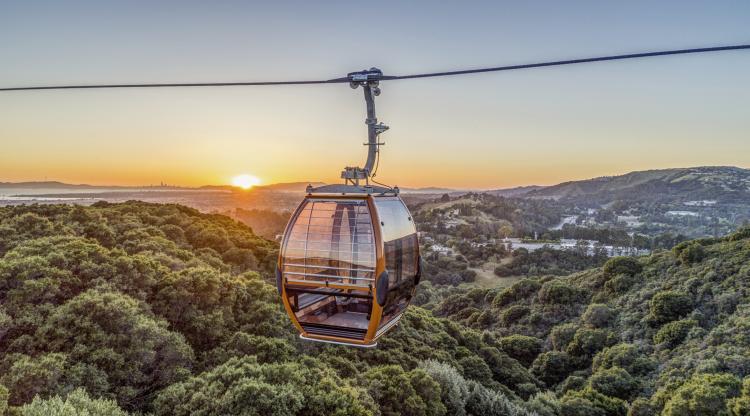 Gondola with view of sunset behind Oakland skyline